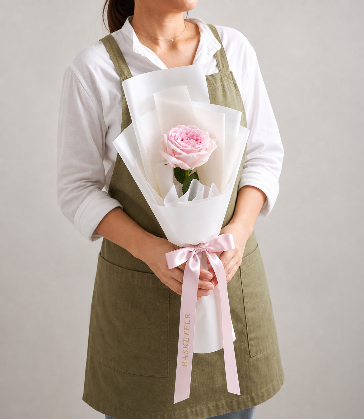 A single, premium light pink rose bouquet, elegantly wrapped in crisp white paper and
