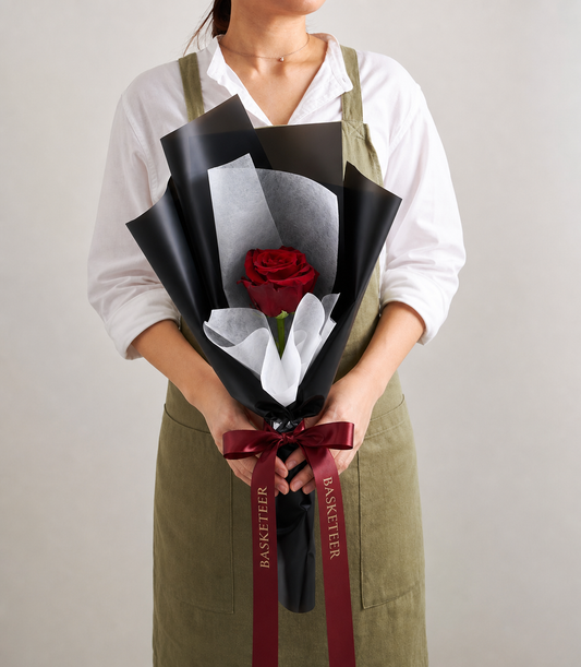 Elegant single red rose bouquet wrapped in luxurious matte black paper and soft