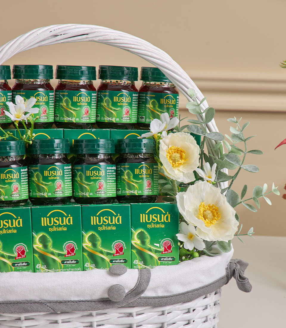 Premium health essence gift basket with dark green bottles, white woven weave, and white-yellow flower arrangement