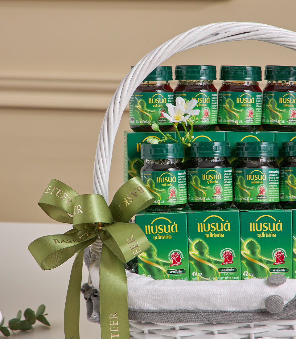 Premium health essentials gift basket with essence bottles, supplements, and wellness boxes in white wicker with green ribbon