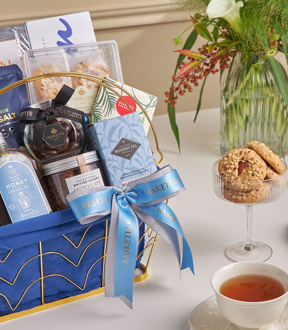Midnight blue luxury gift hamper with gourmet chocolates, honey, tea, and fresh flowers for New Year celebrations