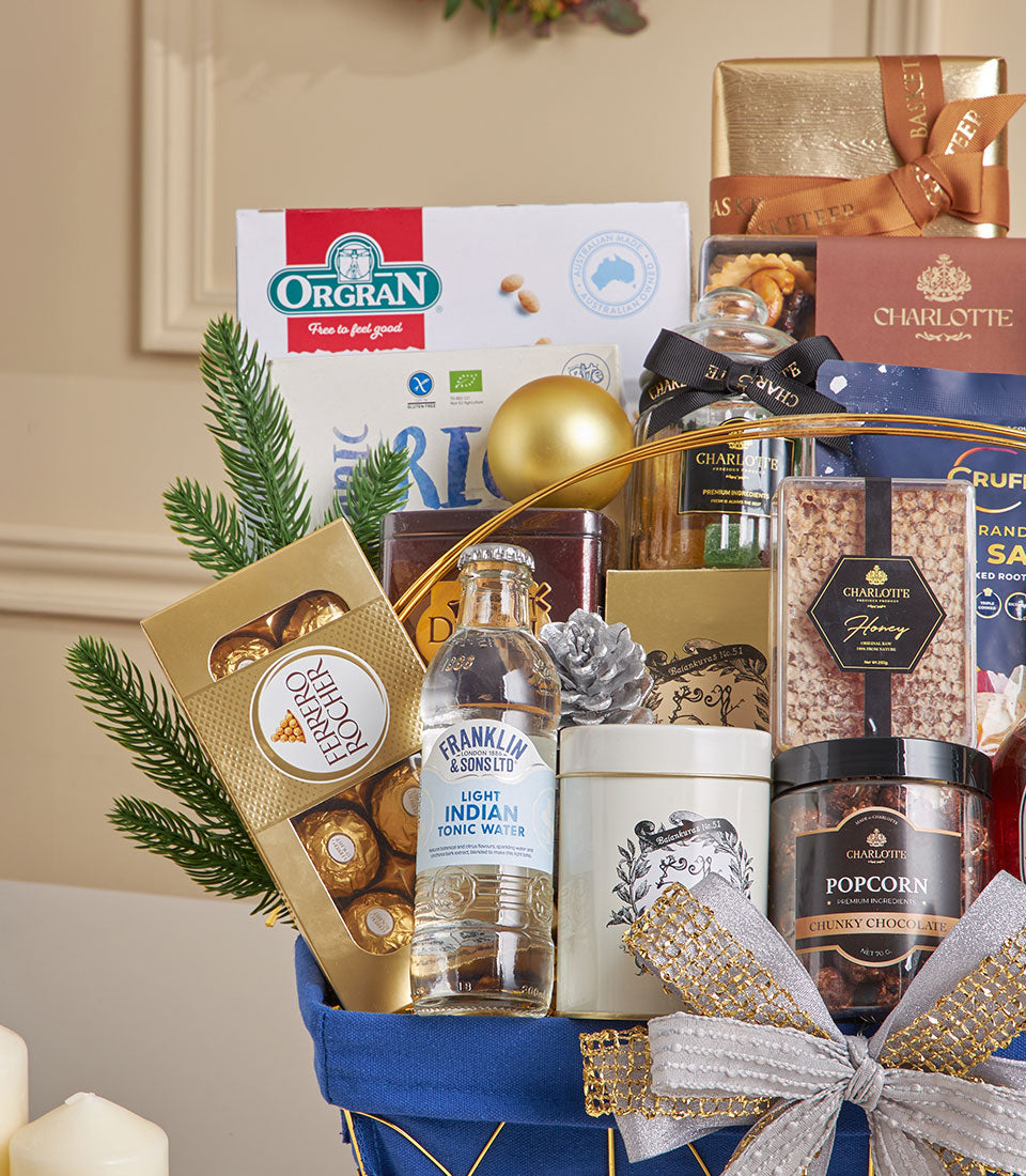 Luxury blue gift basket with Ferrero Rocher chocolates, honey, popcorn, and gourmet treats tied with gold ribbon bow