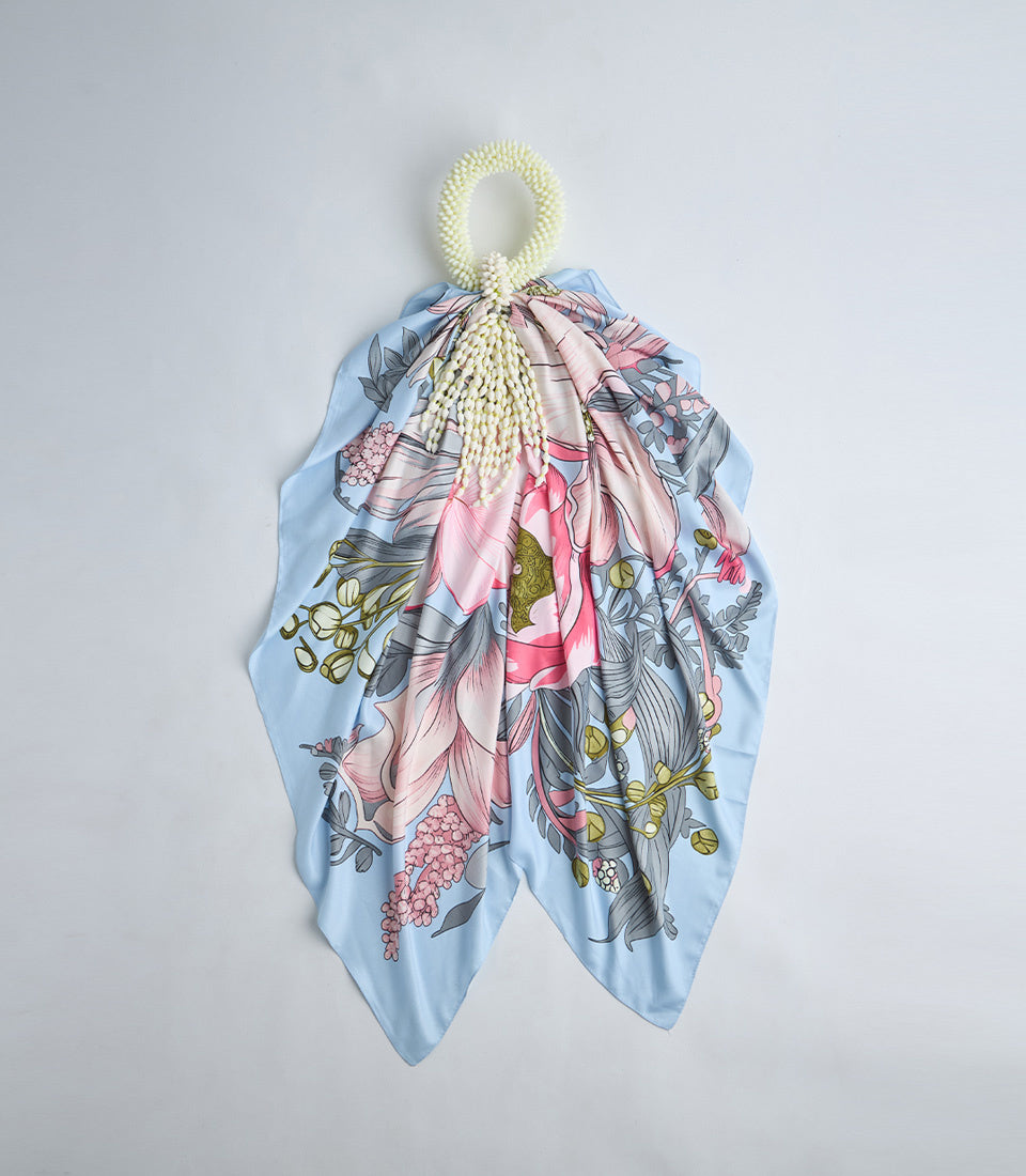 Light blue silk scarf with pink floral print and beaded ivory loop handle, botanical design with hanging fabric panels.