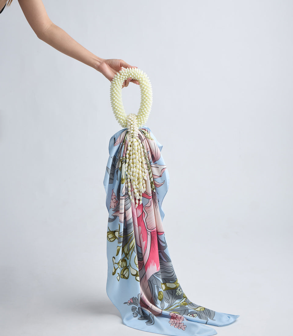 Cream pearl beaded necklace with silk scarf featuring blue, pink, and botanical floral patterns, displayed against white background.