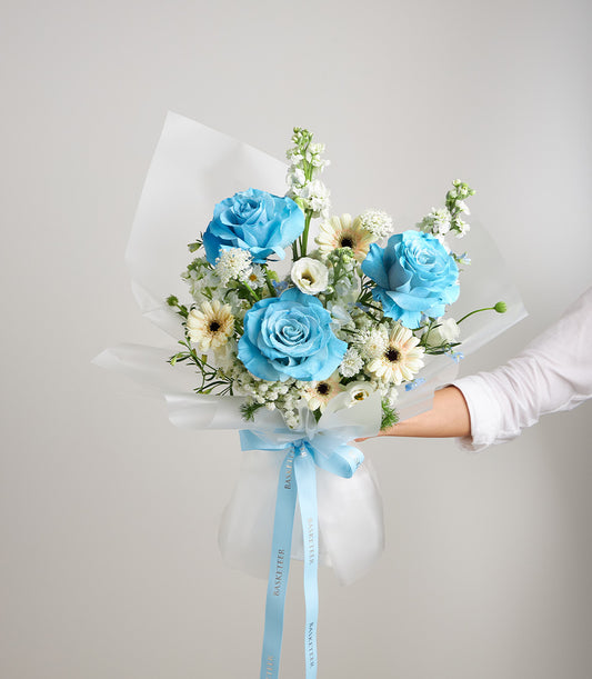 An elegant Flowers by Basketeer bouquet featuring vibrant blue roses, delicate