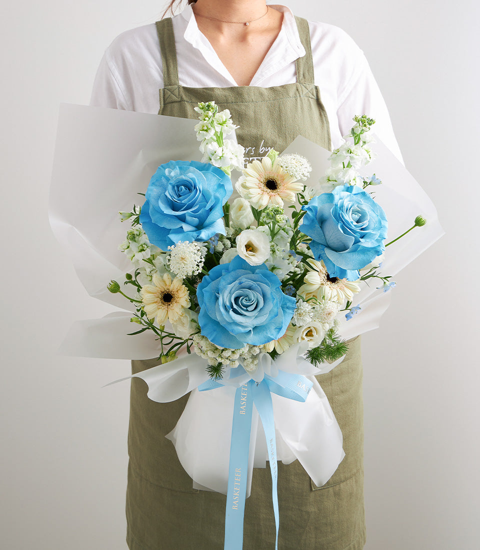 An elegant bouquet of premium blue roses, fresh white stock, and