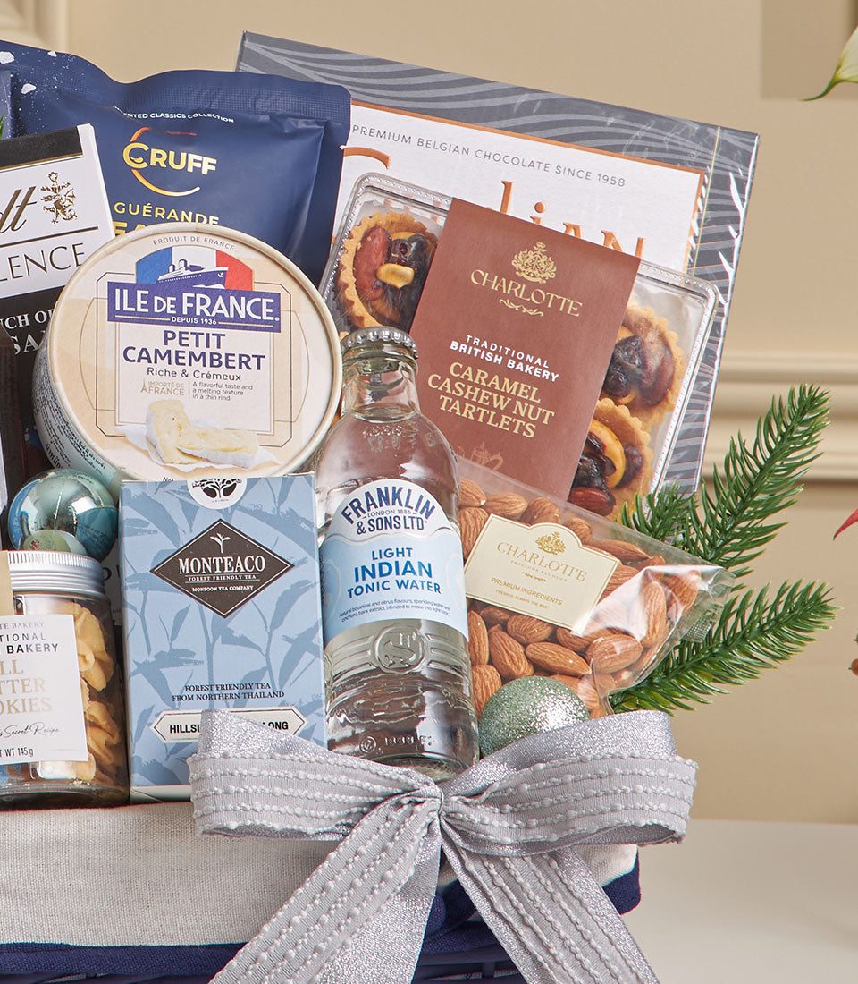 Premium gourmet hamper with sea salt dark chocolate, Camembert cheese, and artisan treats in silver-ribboned basket for New