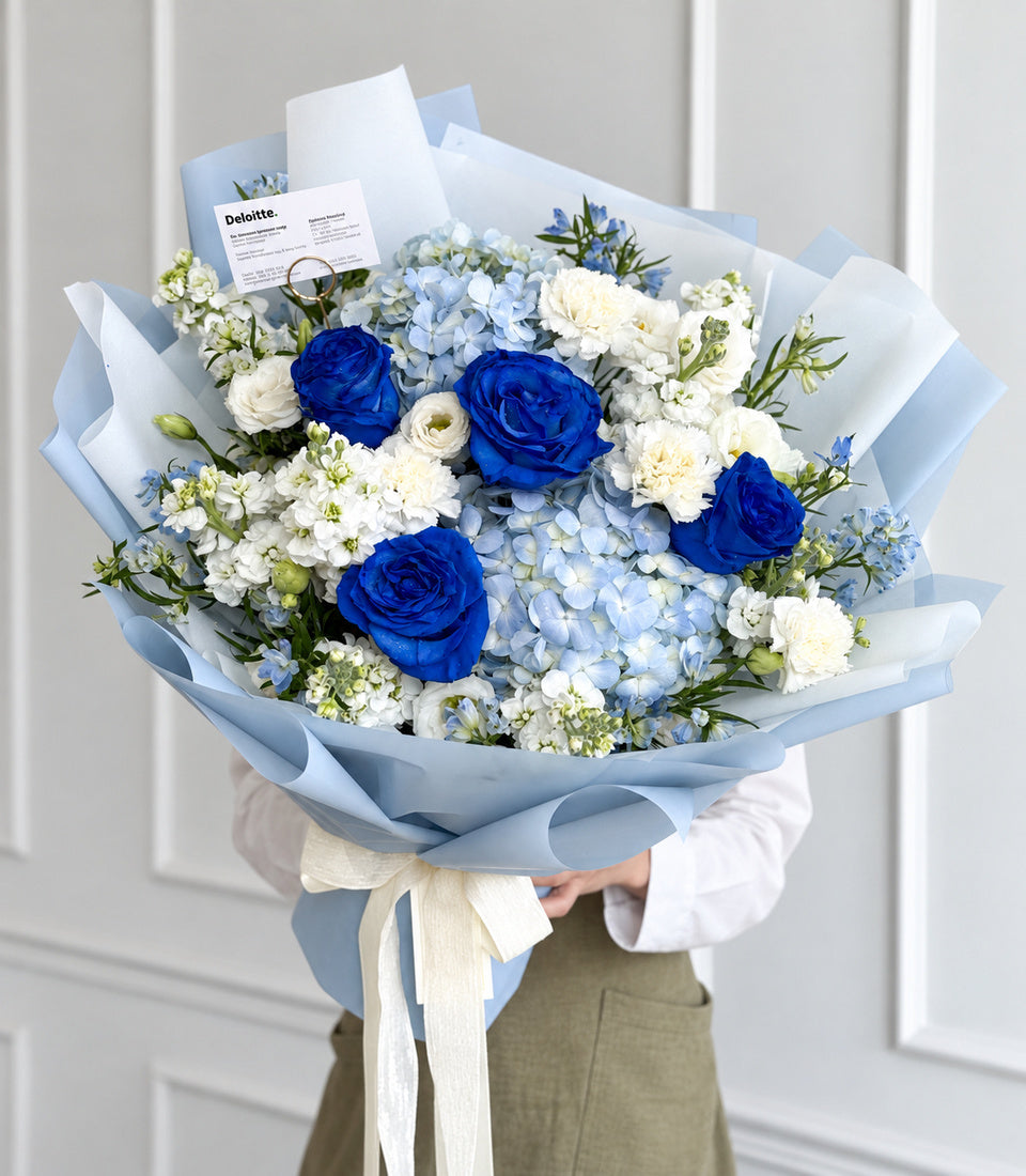 Closer front view of ocean blue roses, pale blue hydrangeas and white flowers