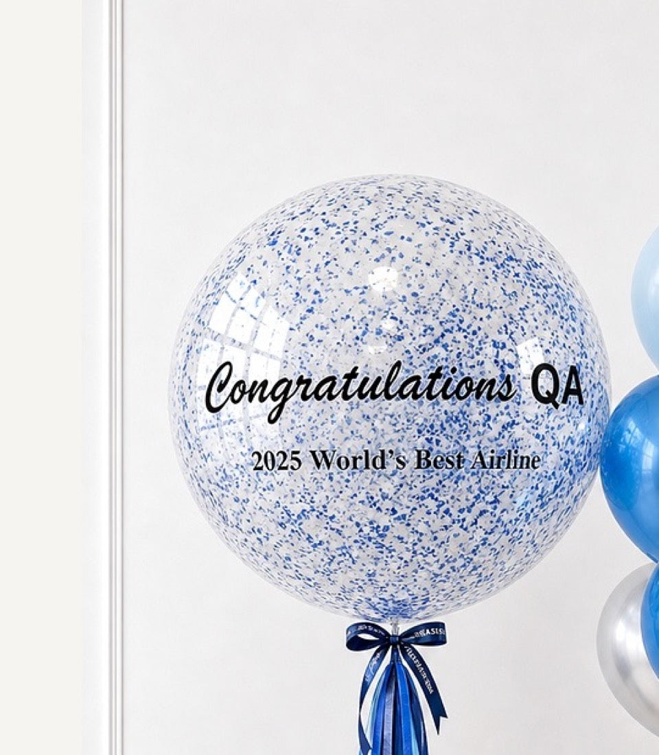 Large clear confetti-filled balloon with blue and white speckles, tied with blue ribbon bow, celebrating Qatar Airways' 2025 World's Best Airline award.