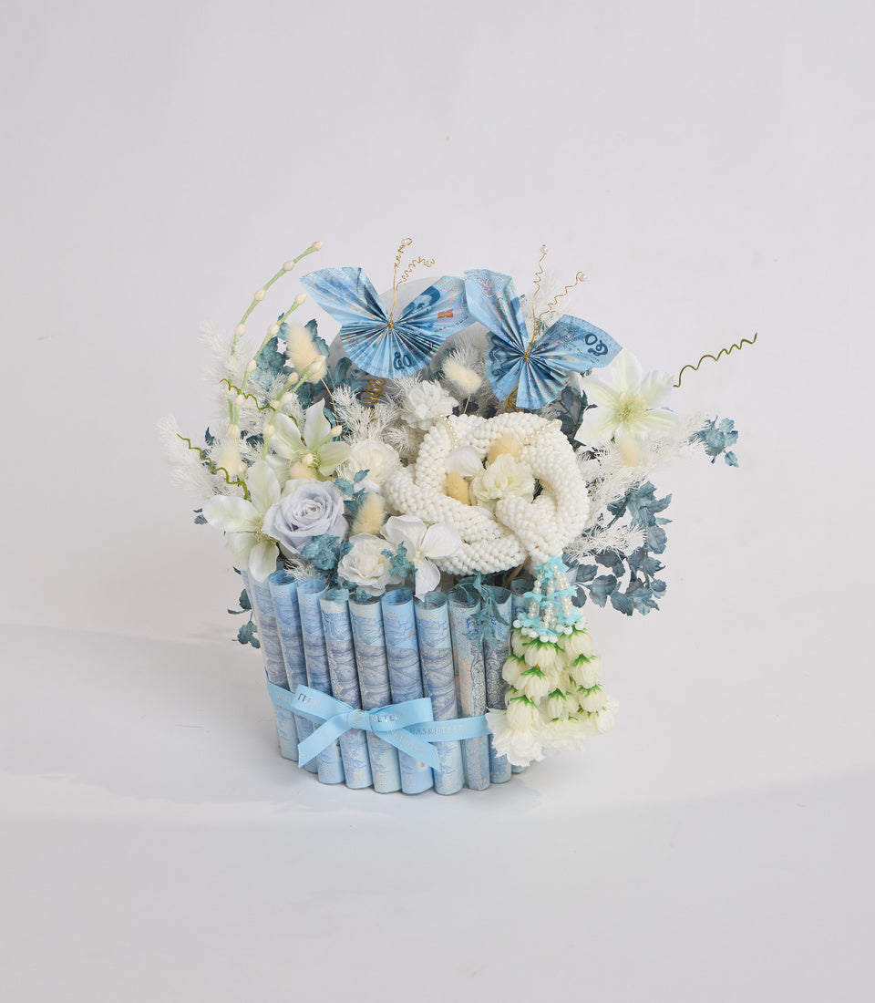 # Alt Text

Luxurious floral arrangement with white roses, cream carnations, and blue euro notes forming container, topped with decorative blue butterfly bows and gold wire accents.