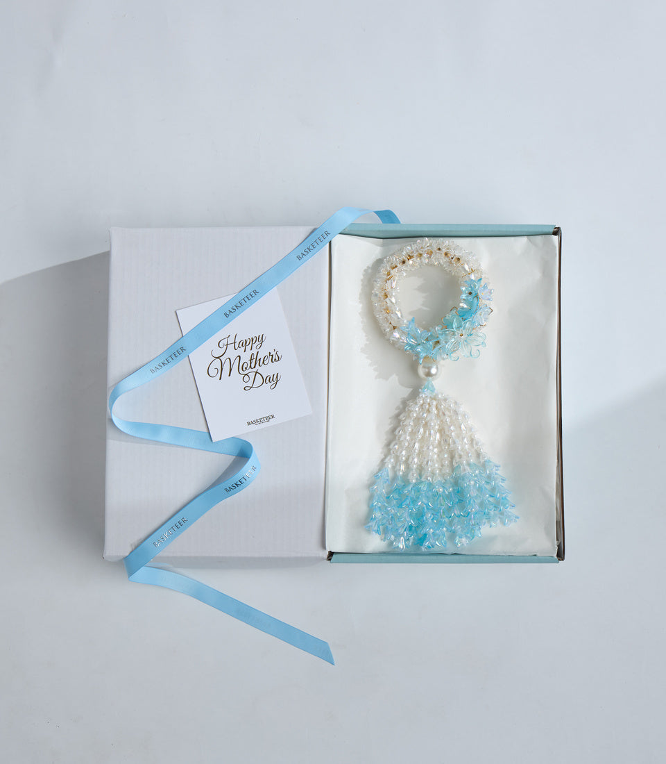 Mother's Day gift set featuring a beaded bracelet and tassel ornament in turquoise and pearl white, presented in an elegant box with blue ribbon.