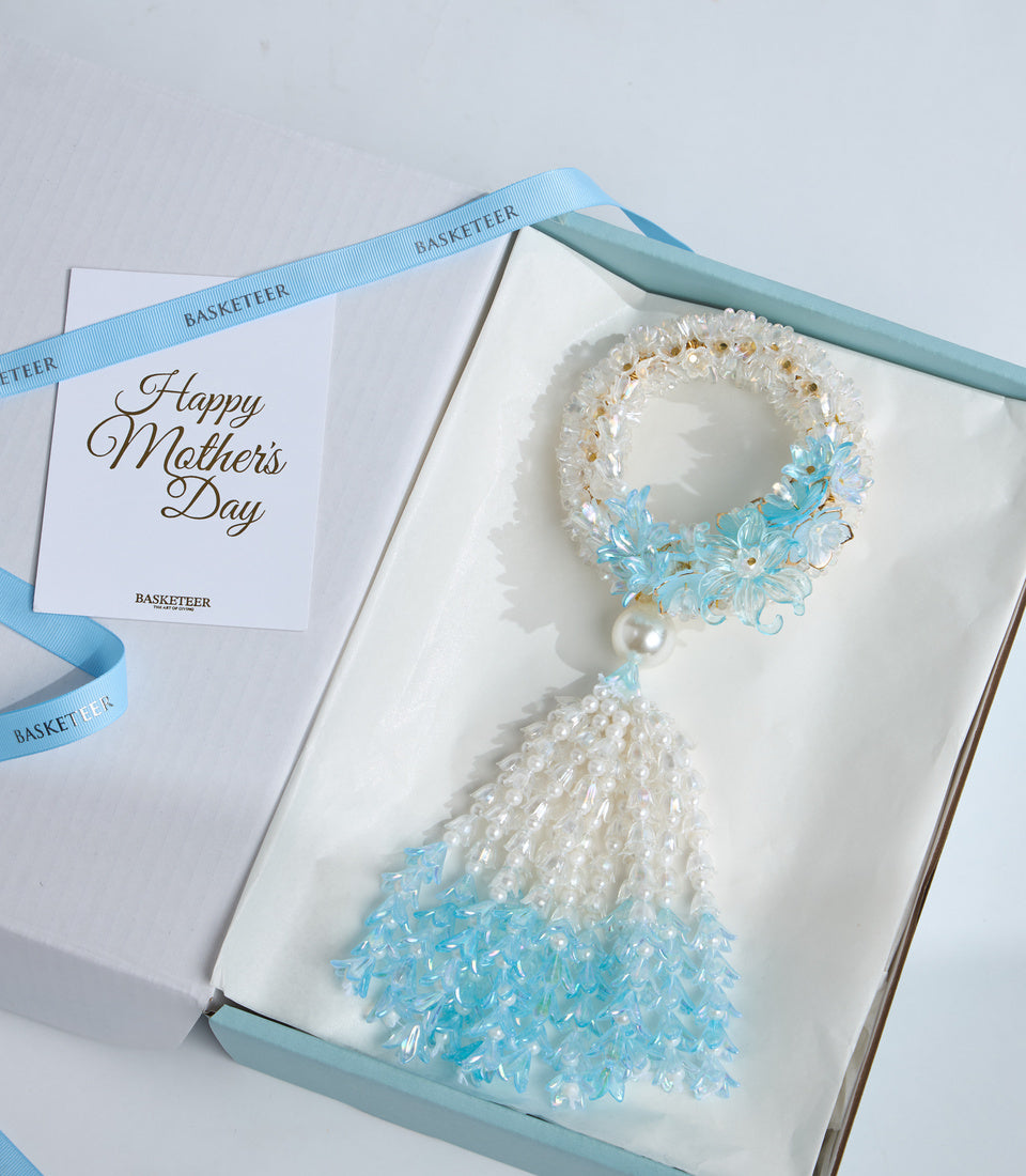 Elegant Mother's Day gift set featuring a beaded bracelet with blue and white crystal beads, pearl accent, and matching greeting card with light blue ribbon.