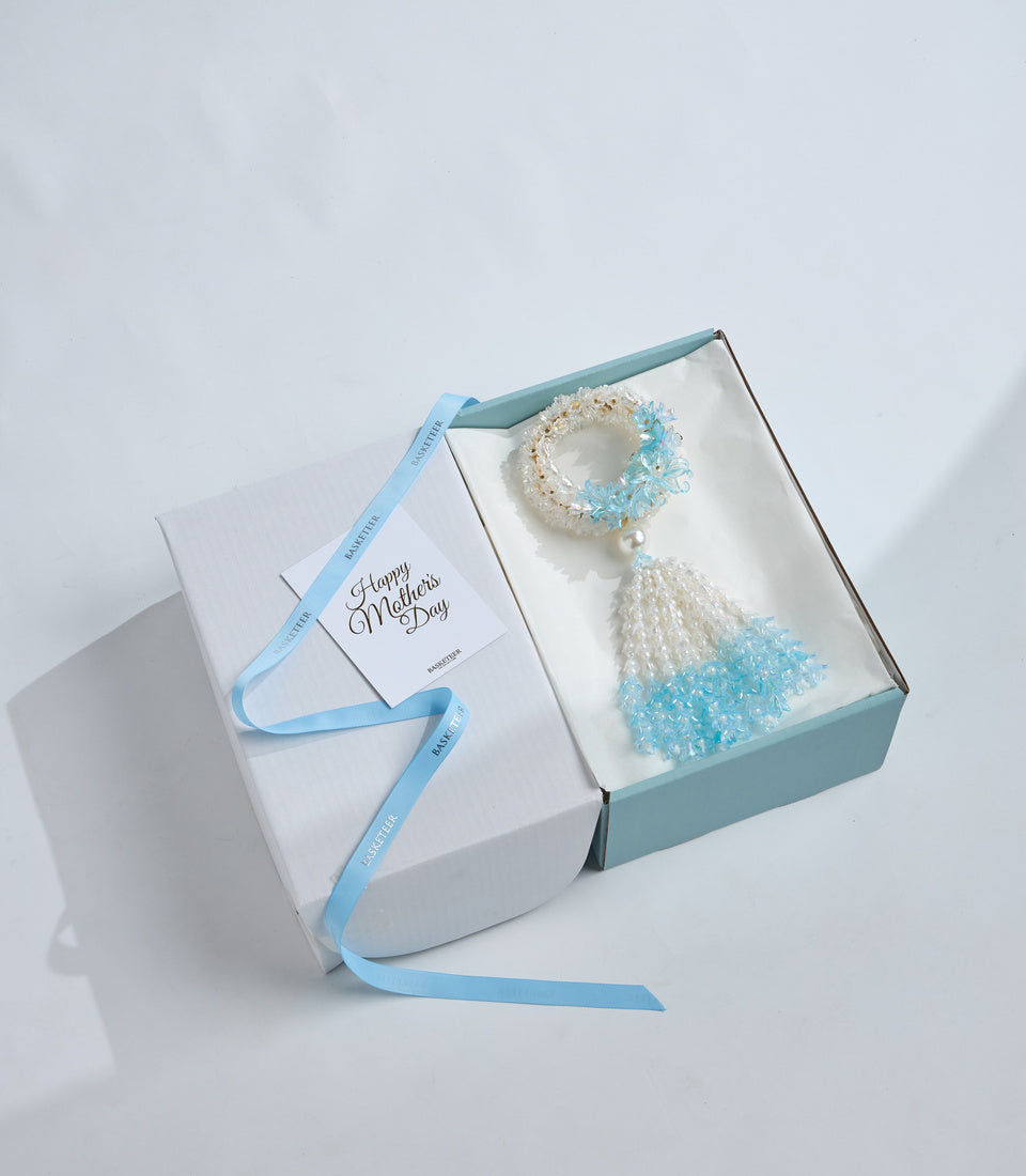 Elegant beaded bracelet gift set with light blue and white crystals, pearl accent, cream packaging, blue ribbon, Mother's Day greeting card.