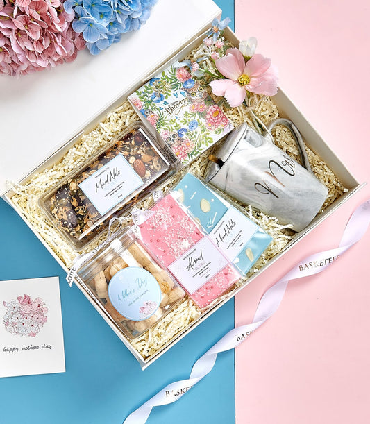 Luxury Mother's Day gift basket with gourmet nuts, artisan cookies, marble mug, and floral notebook