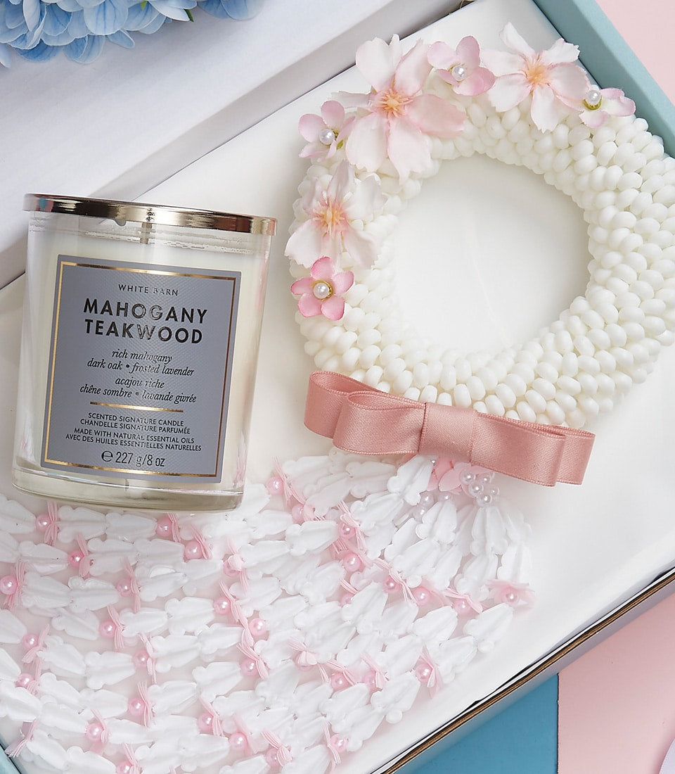 Mother's Day gift set with mahogany teakwood scented candle and white floral garland with pink cherry blossoms