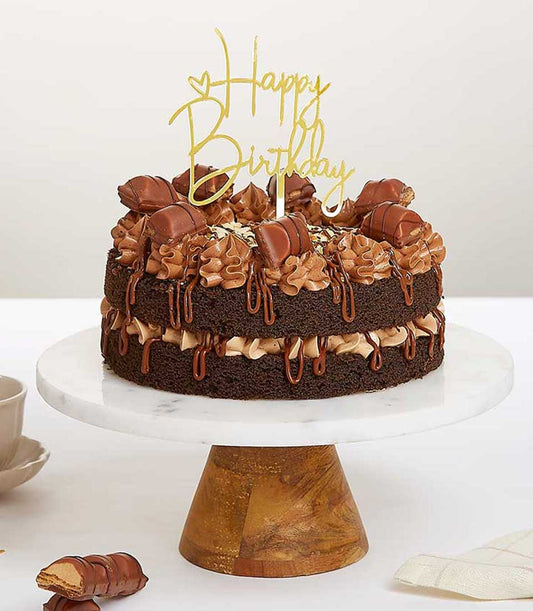 Nutella and Kinder Bueno chocolate birthday cake with gold topper on marble stand