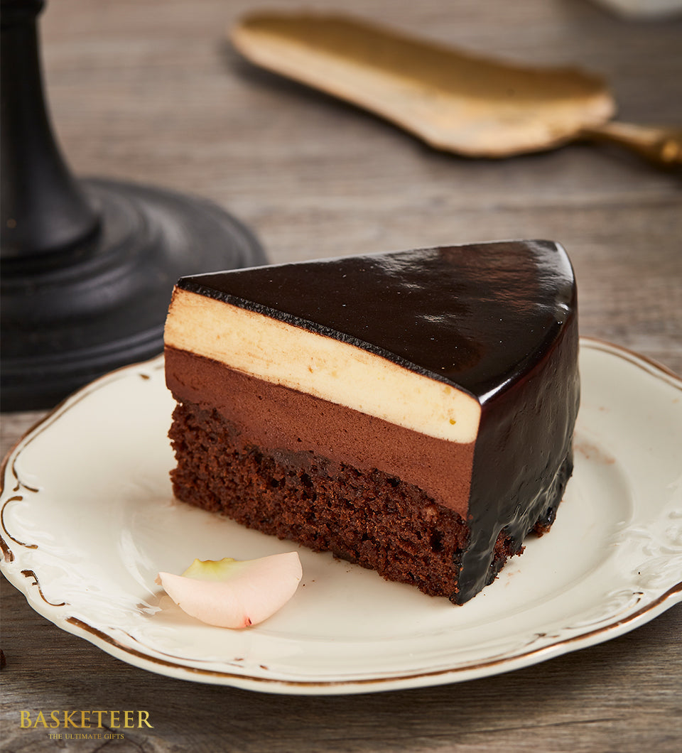 Luxe layered dark chocolate cake slice with mousse topping and gold-rimmed plate