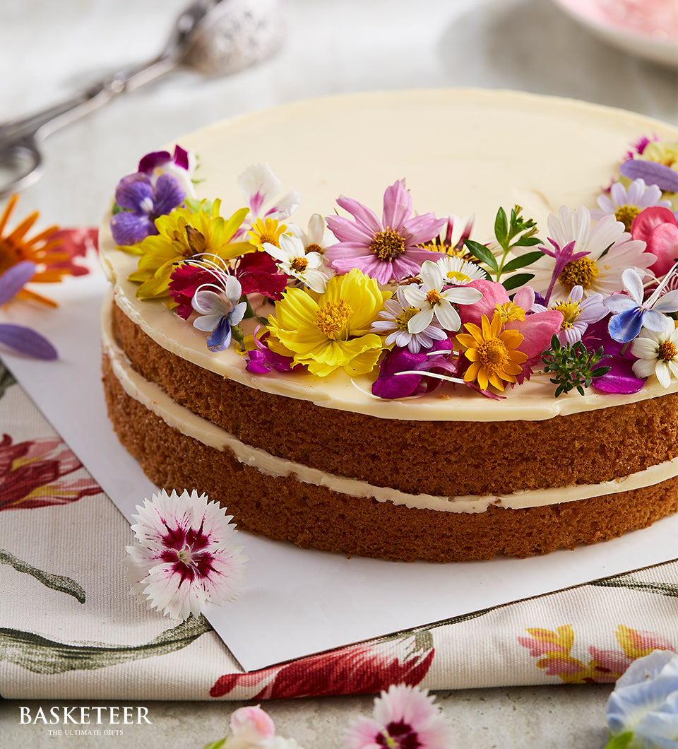 Two-layer vanilla butter cake with fresh edible flowers and cream frosting, birthday celebration cake
