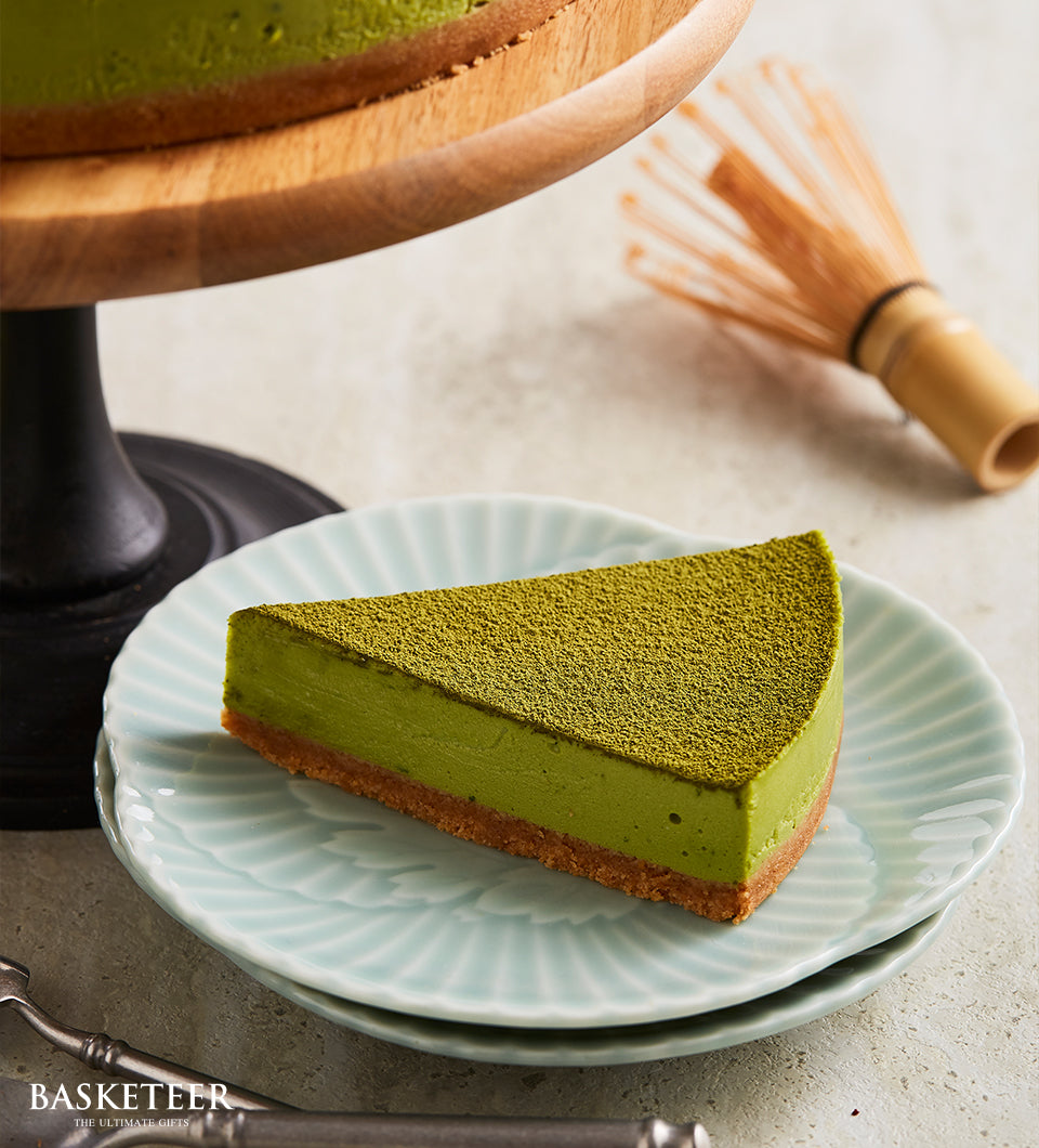 Green matcha cheesecake slice with golden crust on ceramic plate, artisan birthday cake by Charlotte Bakery