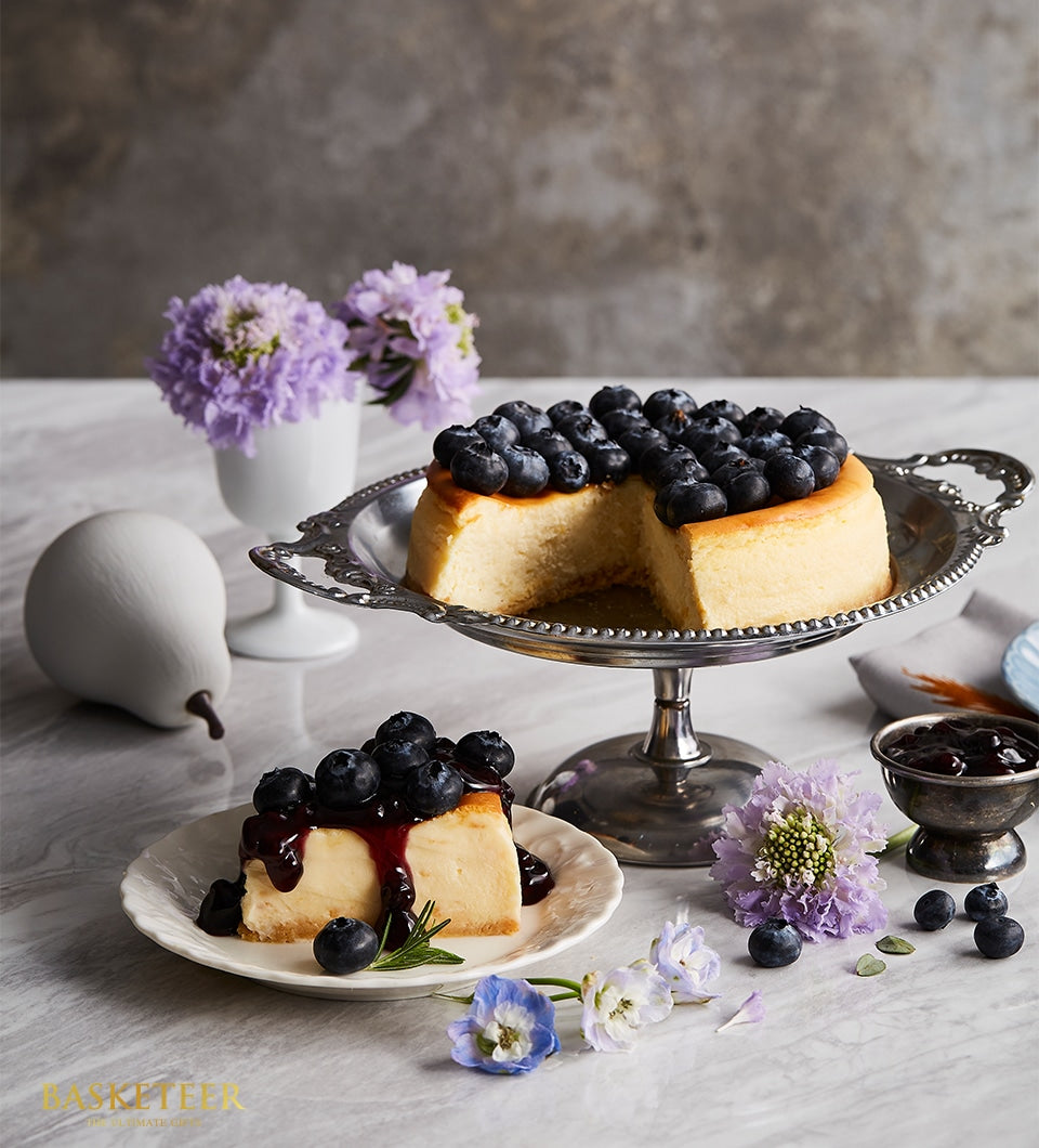 Classic New York cheesecake topped with fresh blueberries, artisan birthday cake with blueberry sauce