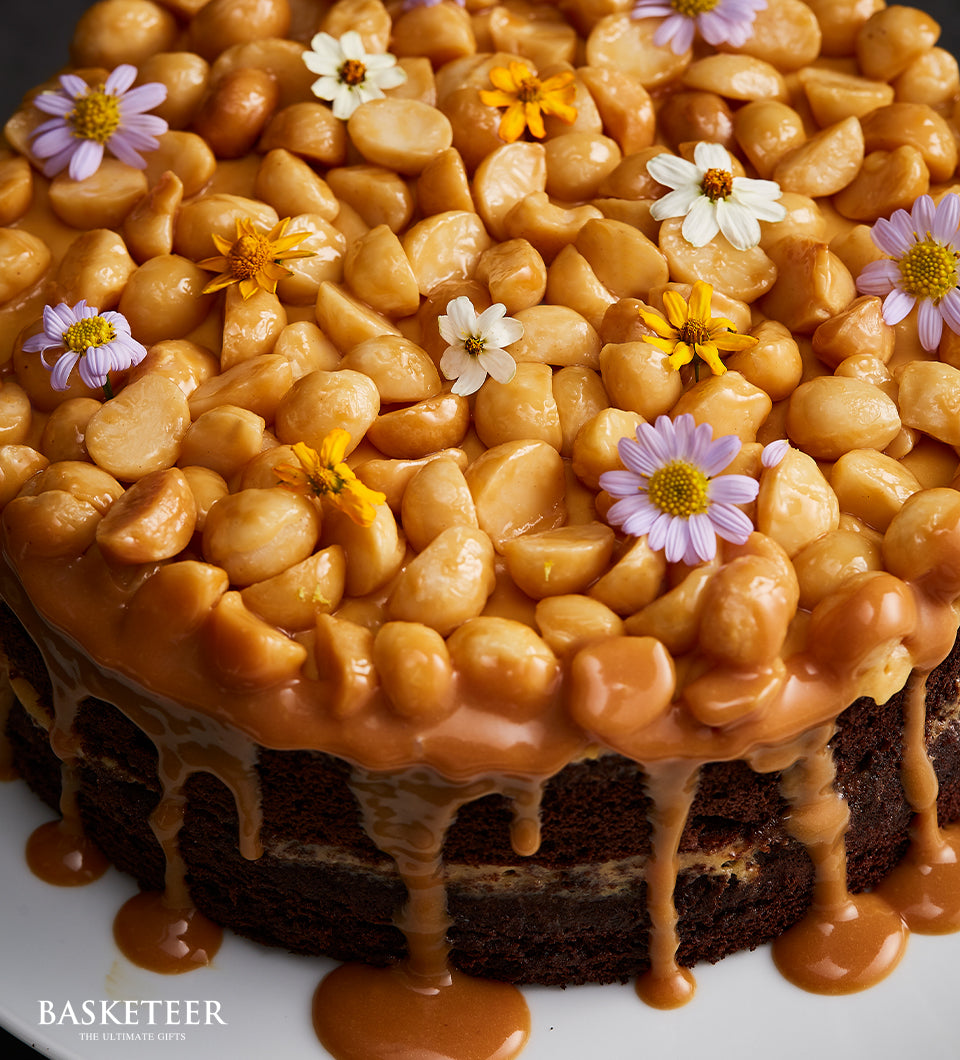 Layered chocolate cake with caramel macadamia nuts and fresh flowers for birthday celebrations