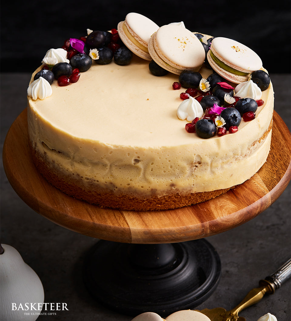 Berry Bliss vanilla cheesecake with macaron toppers and fresh blueberries, artisan birthday cake by Charlotte Bakery