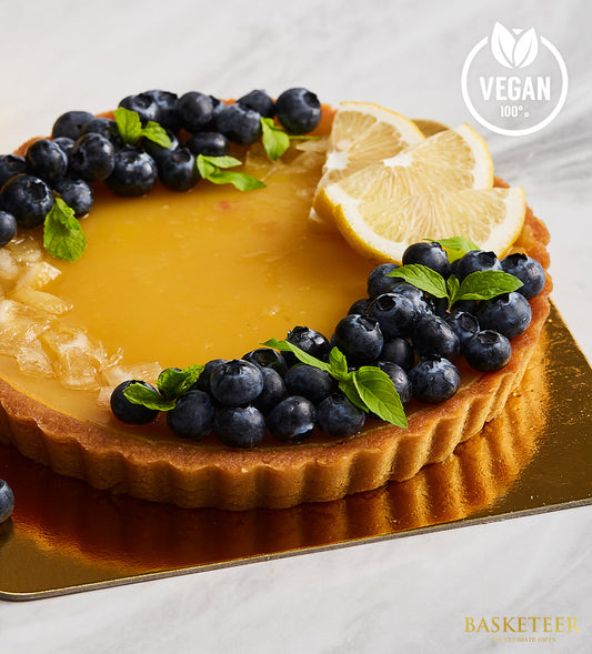 Zesty blueberry lemon vegan tart with golden crust and bright lemon curd, garnished with fresh berries and mint