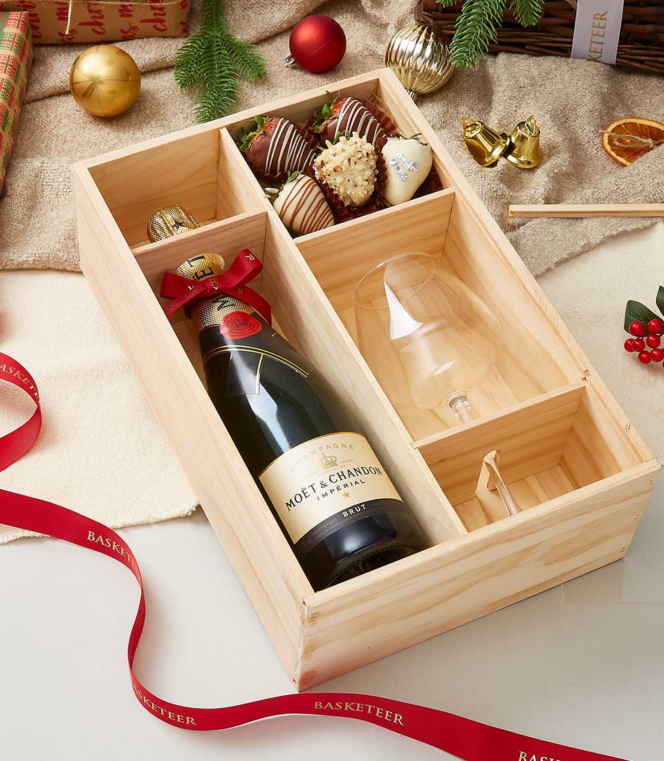 Champagne and chocolate-covered strawberries Christmas gift box with Moët & Chandon, flute, and festive baubles