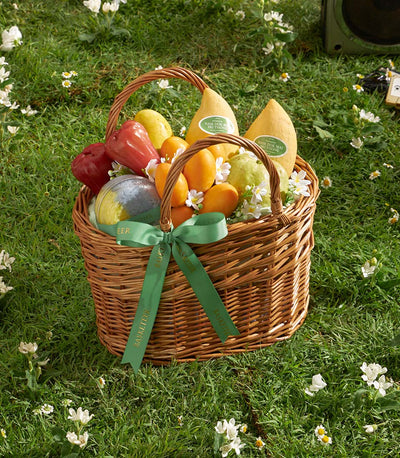 Golden Harvest mango gift basket with fresh tropical fruits and decorative globe on wicker picnic basket