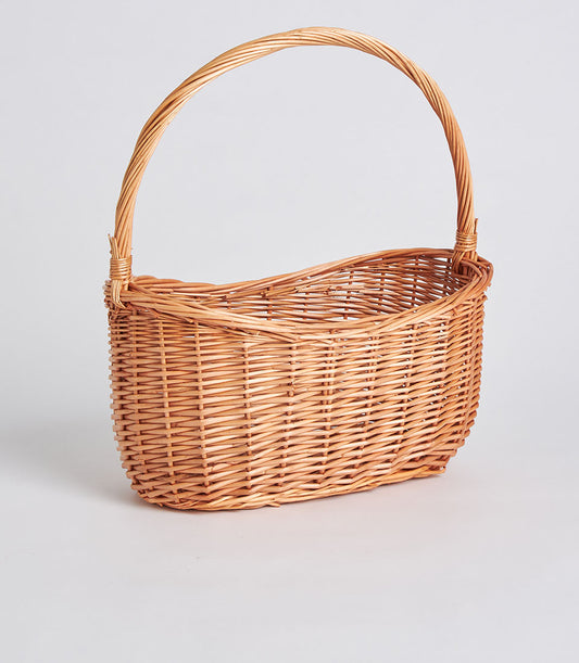 Light brown handwoven oval wicker basket with tall arched handle for premium gift packaging