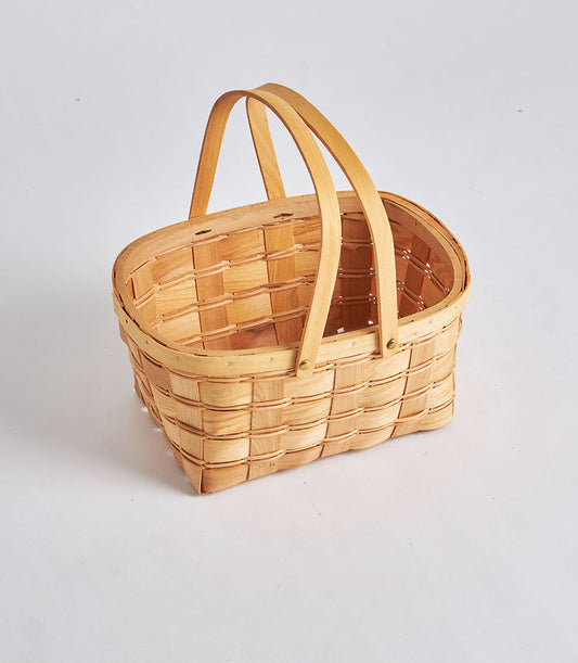 Light woven oval wicker basket with dual wooden handles, handcrafted for artisan gift hampers