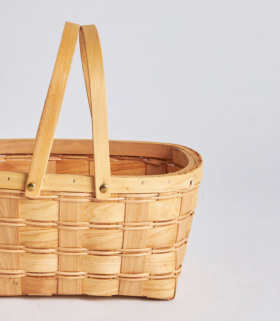 Natural woven wicker basket with dual wooden handles for gourmet gift hampers