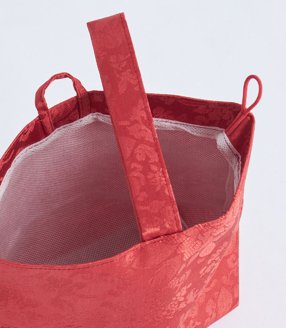 Red brocade fabric gift basket with handle and white mesh lining