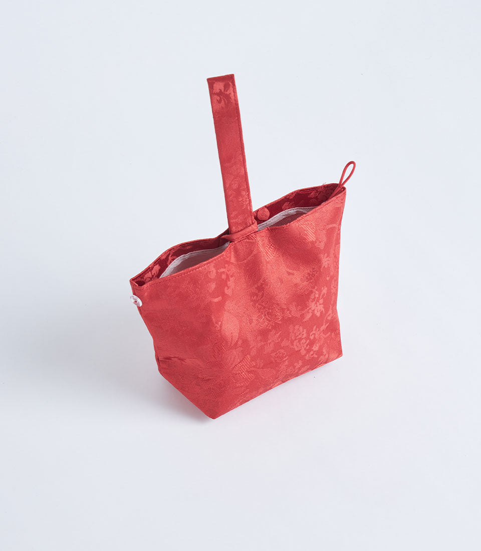 Red brocade fabric gift basket with jacquard floral pattern and handle