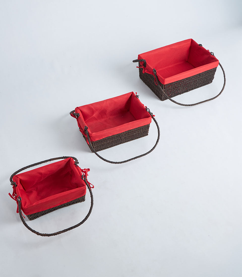 Handwoven rectangular wicker baskets with red fabric liners and braided handles in three sizes