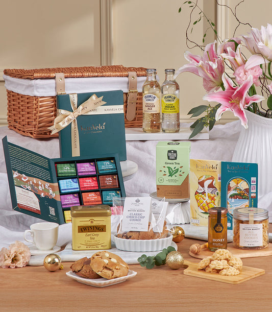 Luxury tea and cookie tasting hamper with wicker basket, gourmet chocolates, and fresh flowers for New Year gifting