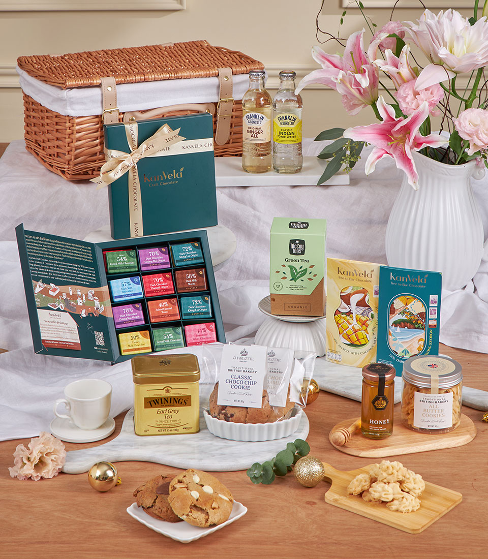 Luxury tea and cookie hamper with wicker basket, chocolates, Earl Grey, and fresh flowers for New Year gifting
