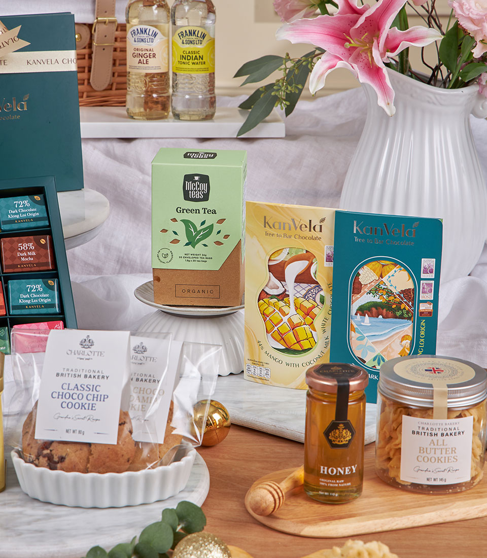 Luxury tea and cookie tasting hamper with gourmet chocolates, honey, and beverages in wicker basket for New Year gifting