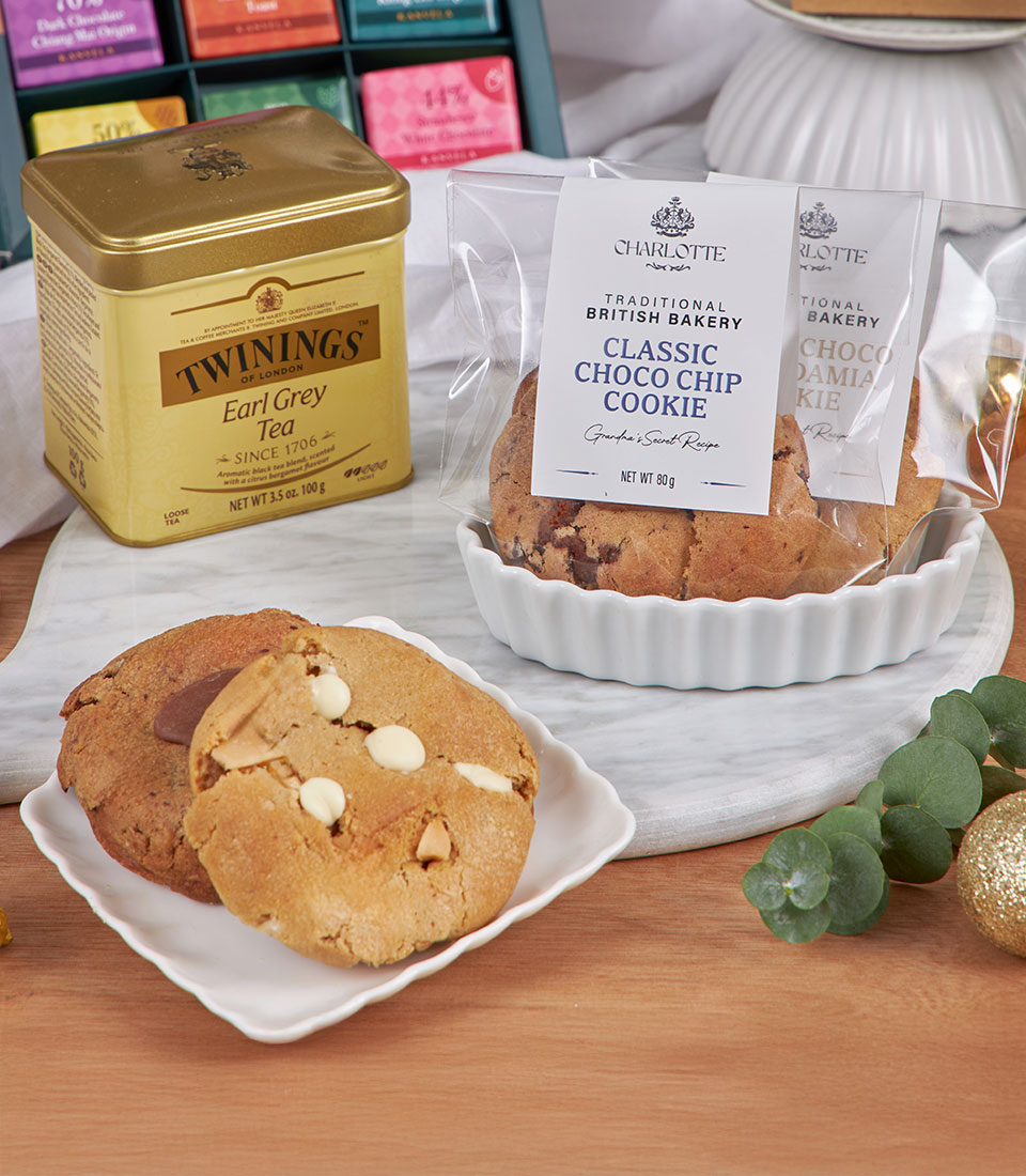 Premium tea and cookie gift hamper with Earl Grey tin, artisan chocolate chip cookies, and festive gold accents for New Year