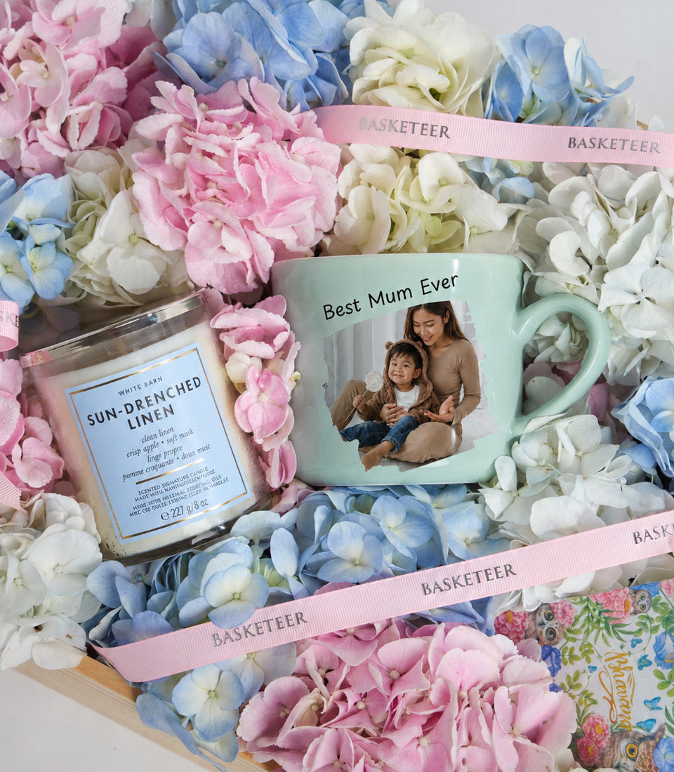 # Alt Text

Personalized "Best Mum Ever" mint green mug with photo beside a scented candle, surrounded by pink, blue, and white flowers with pink ribbons.