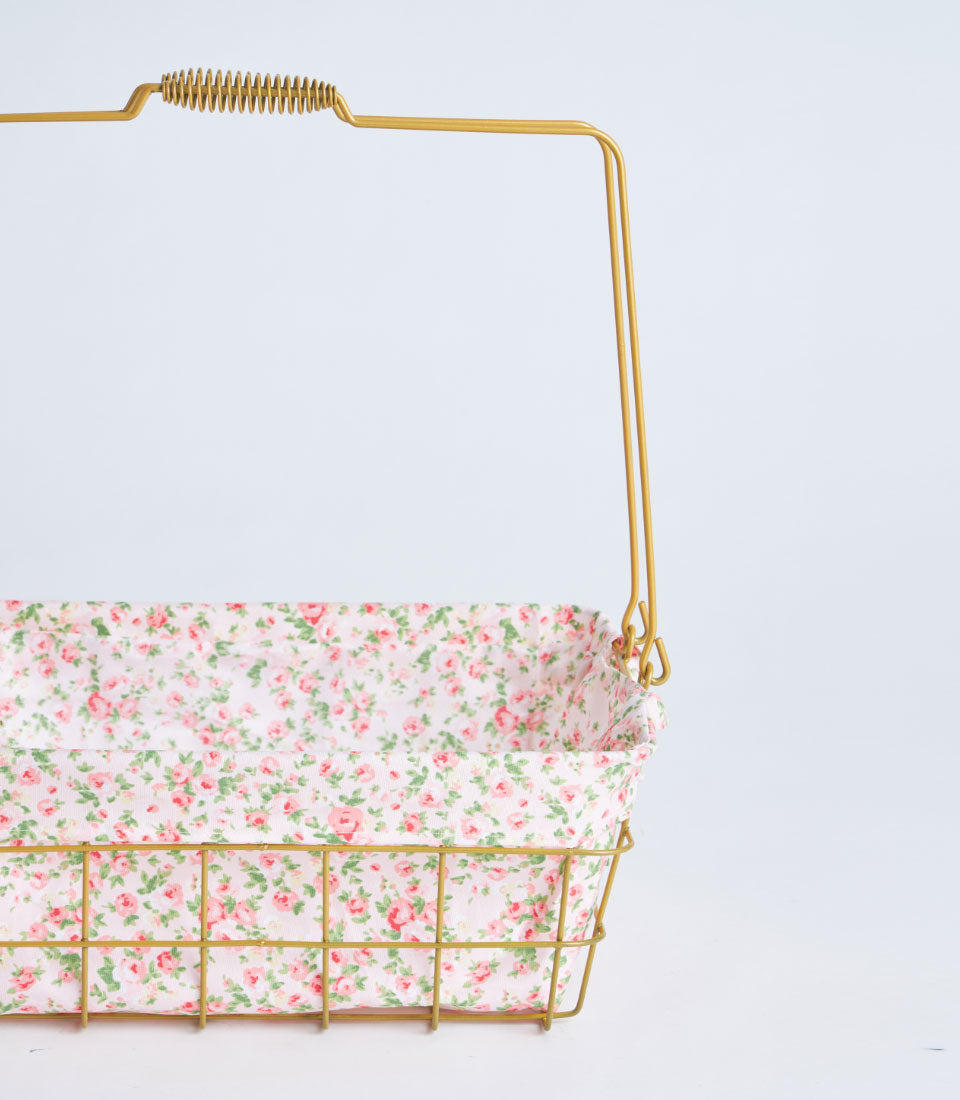Gold metal rectangular basket with delicate pink floral fabric lining and handle