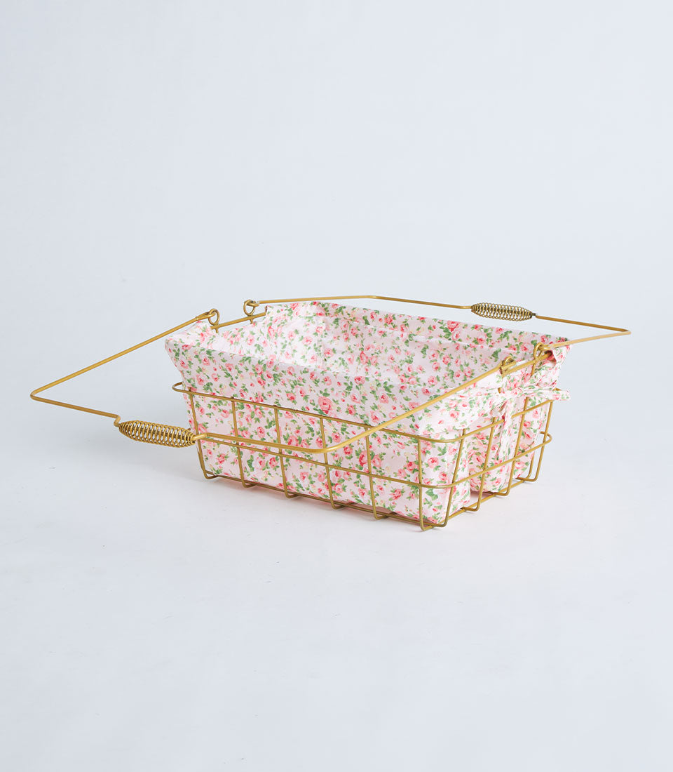 Gold rectangular wire basket with rose-patterned pink fabric lining and dual handles