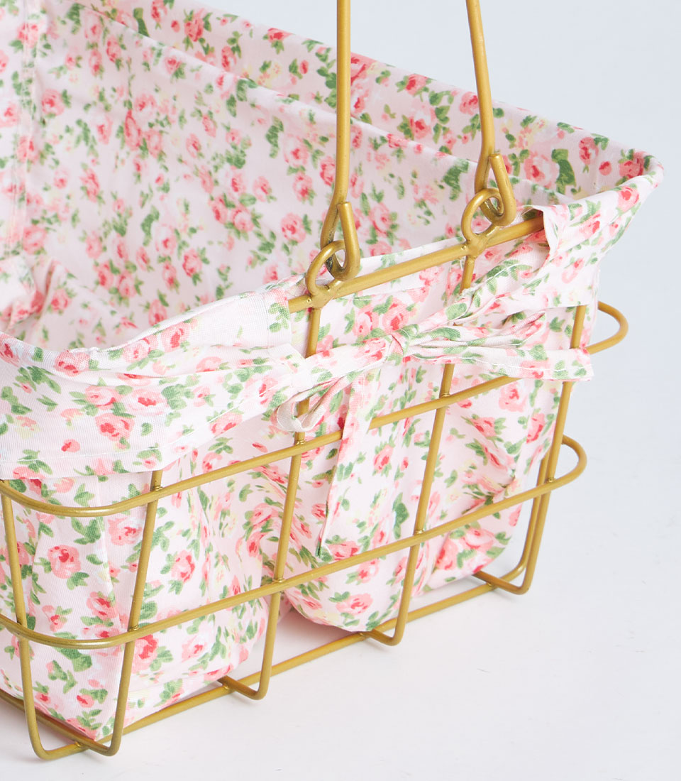 Gold rectangular wire basket with removable rose-patterned pink fabric lining and handles