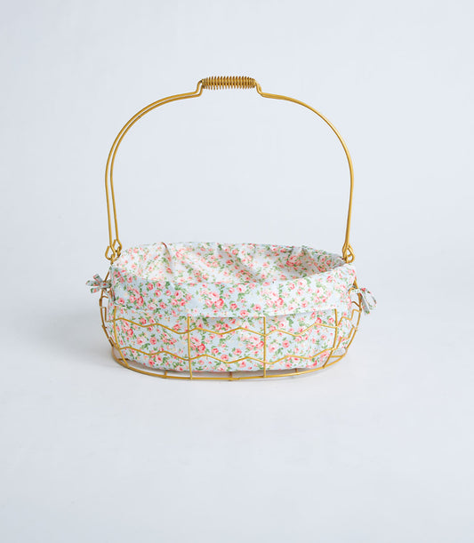 Gold oval wire basket with rose-patterned fabric lining and curved handle