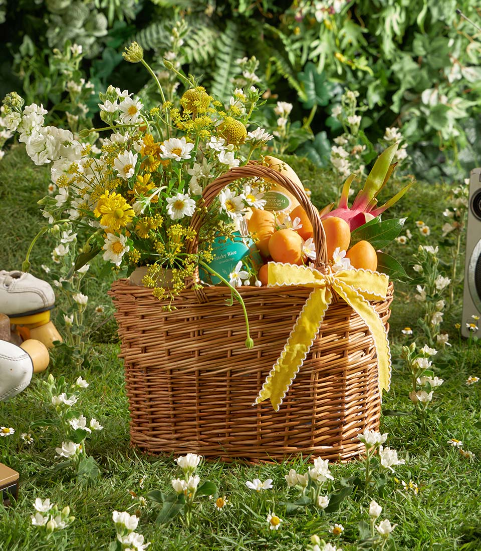 Premium mango and orchid gift basket with fresh white and yellow flowers, tropical fruits, and Thai sticky rice