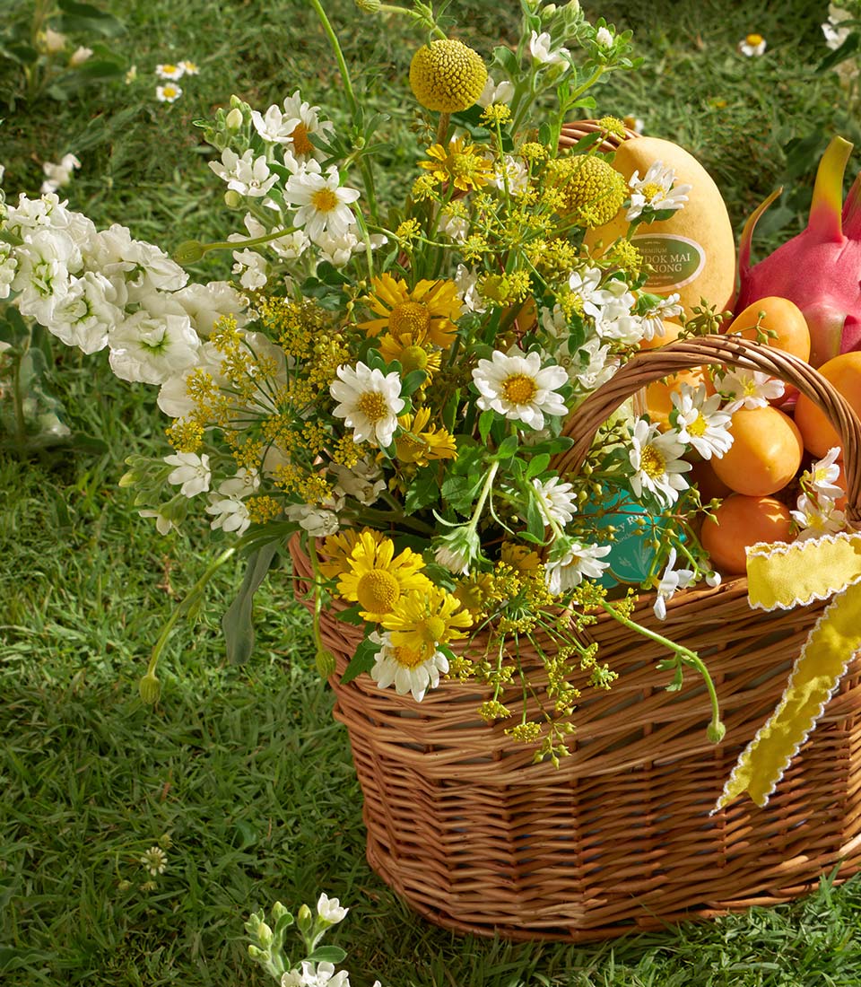 Premium mango and mayongchid gift basket with fresh flowers, white stock and daisies on green lawn