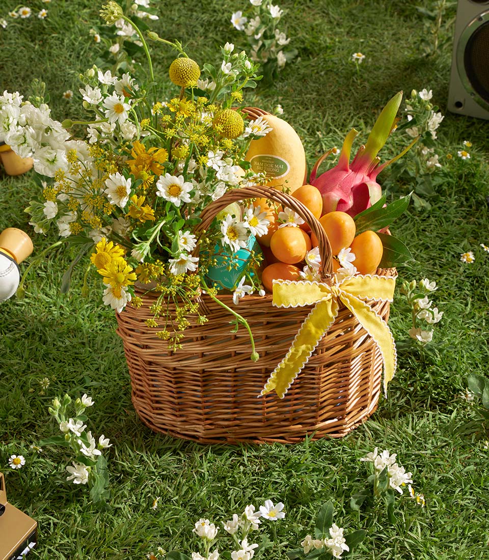 Premium mango and dragon fruit gift basket with white wildflowers and yellow ribbon