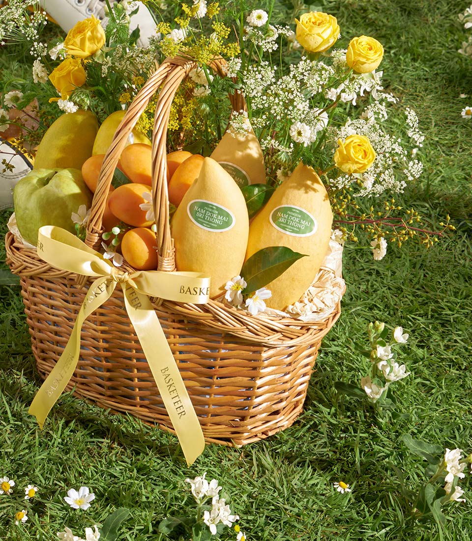 Premium mango and guava gift basket with yellow roses and white flowers, wicker hamper with golden satin bow
