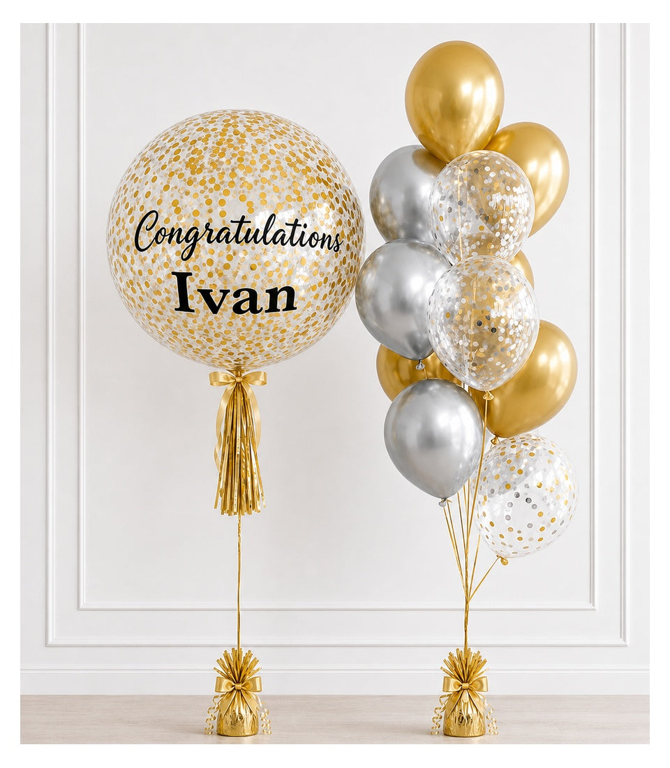 Elegant congratulations balloon arrangement with large gold confetti balloon personalized with "Ivan" name, paired with metallic gold and silver balloons with gold tassels.