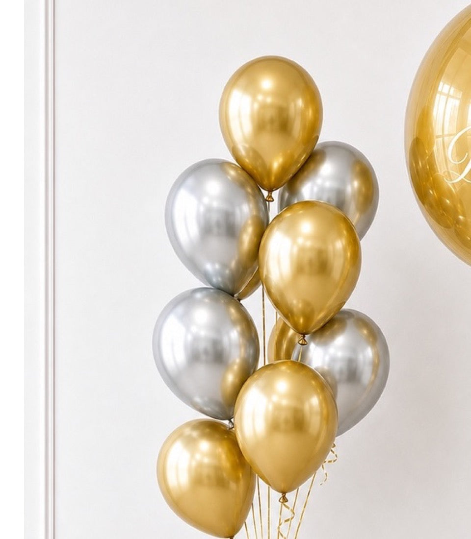 Bunch of metallic balloons in gold and silver, featuring shiny pearl finish against white background with decorative balloon on right.